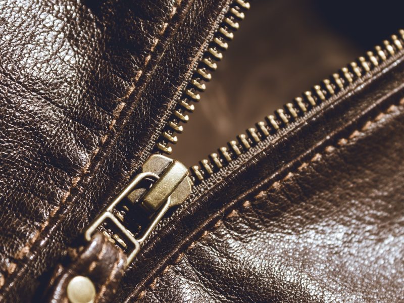 Brown leather texture and metal zipper . Fragment of leather jacket