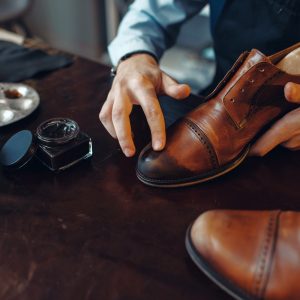 Shoemaker applies shoe polish, footwear repair